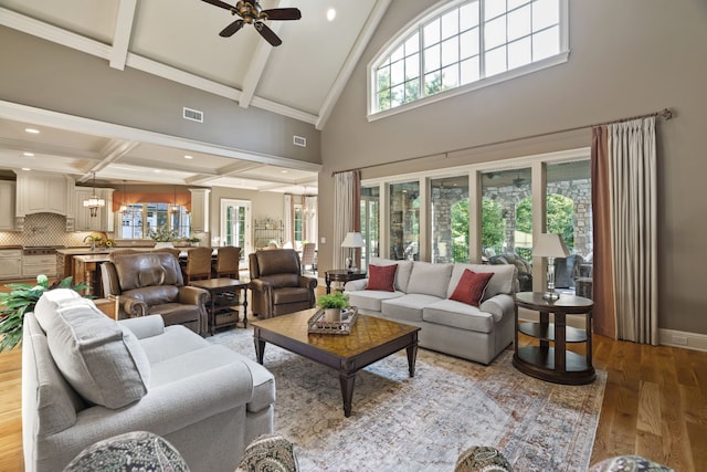 living room with high vaulted ceiling, ceiling fan, beamed ceiling, and hardwood / wood-style flooring