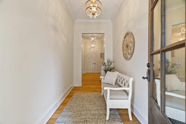 corridor featuring crown molding, an inviting chandelier, and hardwood / wood-style floors