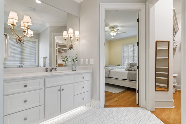 bathroom with tile flooring, ceiling fan with notable chandelier, crown molding, and large vanity