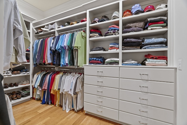 walk in closet with light hardwood / wood-style flooring