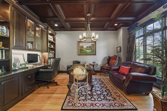 office space with an inviting chandelier, built in desk, coffered ceiling, and light hardwood / wood-style floors