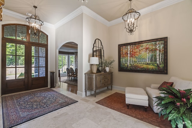 entryway with tile floors, an inviting chandelier, crown molding, and french doors