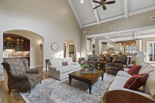 living room with beamed ceiling, high vaulted ceiling, ceiling fan, and hardwood / wood-style floors