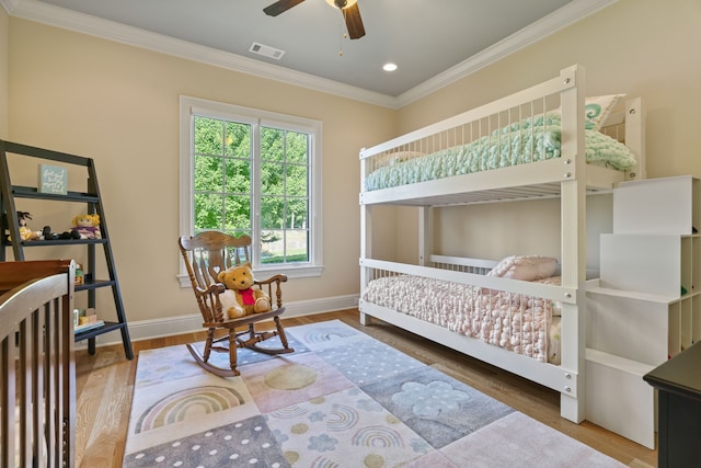 bedroom featuring hardwood / wood-style floors, ceiling fan, and crown molding