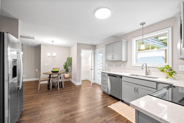 kitchen with gray cabinetry, decorative light fixtures, and appliances with stainless steel finishes