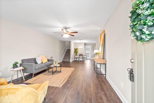 living room featuring ceiling fan and dark hardwood / wood-style floors