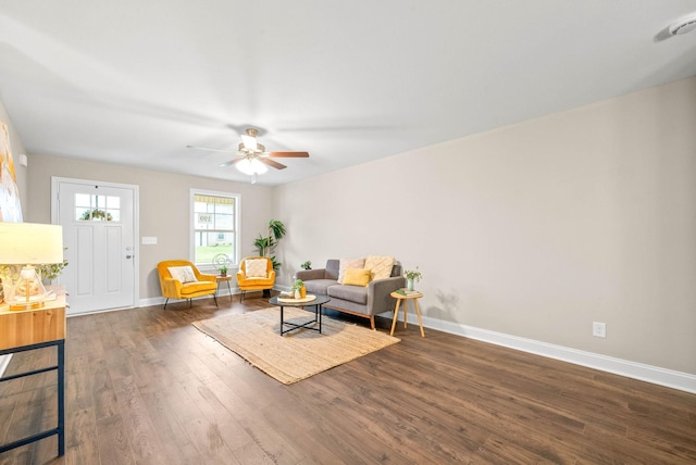 living room featuring ceiling fan and dark wood-type flooring