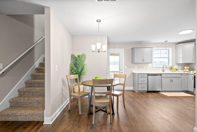 dining space featuring plenty of natural light, dark hardwood / wood-style floors, sink, and an inviting chandelier