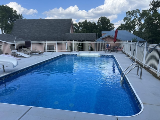 view of swimming pool with a patio and a water slide