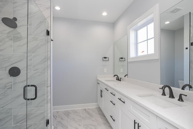 bathroom with vanity, toilet, and a shower with door