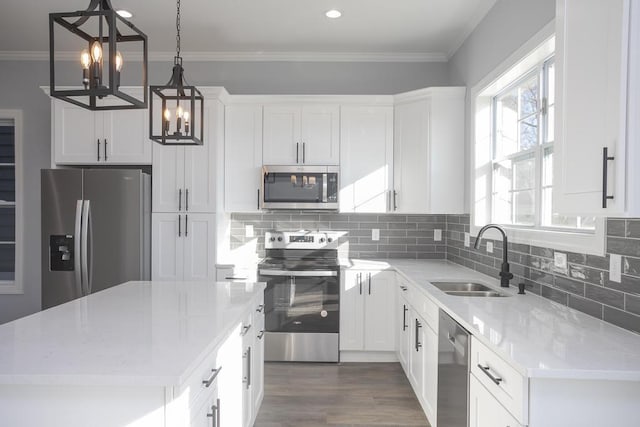 kitchen with white cabinetry, a kitchen island, pendant lighting, and appliances with stainless steel finishes