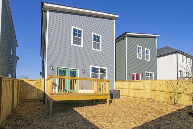 rear view of house with cooling unit and a wooden deck