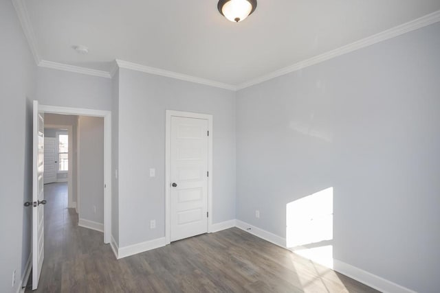 empty room with dark hardwood / wood-style flooring and crown molding