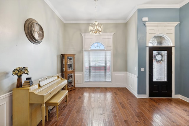 foyer entrance with an inviting chandelier, crown molding, and dark wood-type flooring