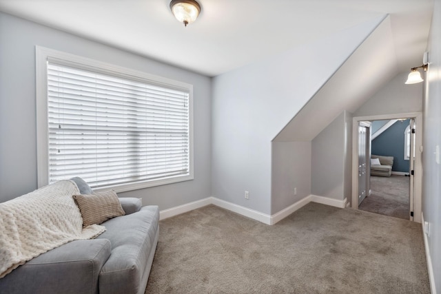 living area featuring light carpet and vaulted ceiling