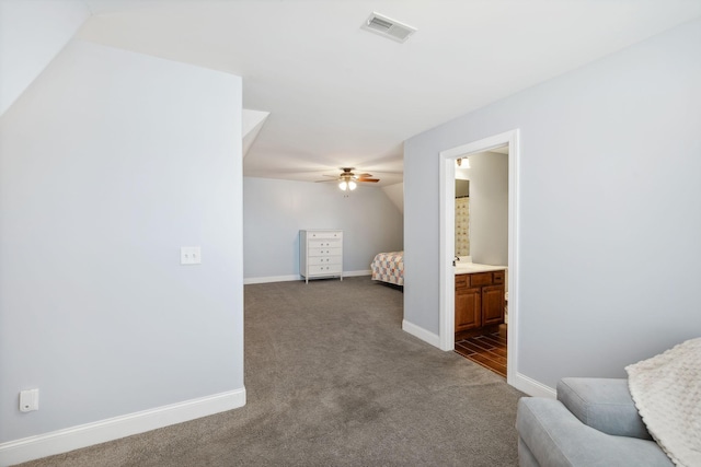 corridor featuring dark colored carpet and lofted ceiling