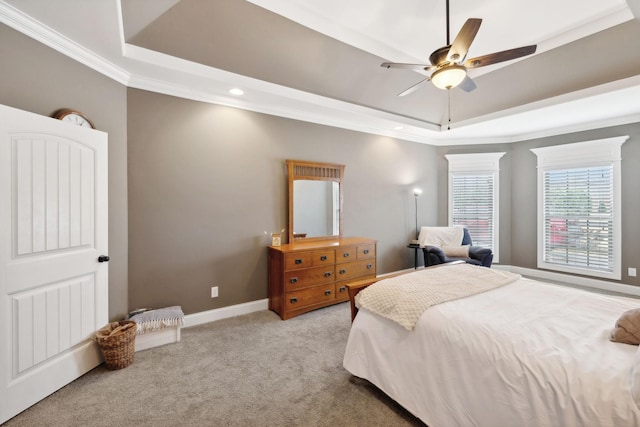 carpeted bedroom featuring a raised ceiling, ceiling fan, and crown molding