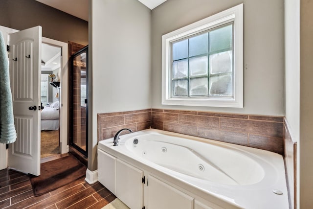 bathroom featuring plus walk in shower and hardwood / wood-style flooring