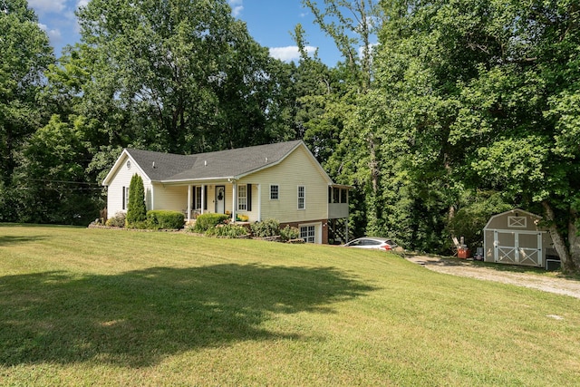 view of front of property with a porch, a storage shed, and a front lawn