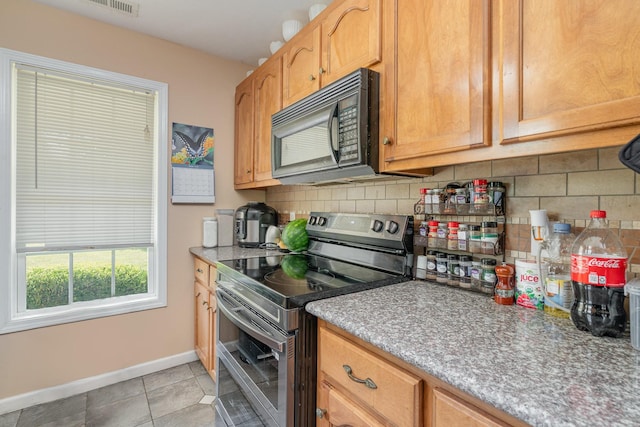 kitchen featuring light tile patterned flooring, tasteful backsplash, and stainless steel electric range