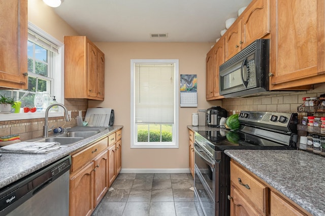 kitchen with appliances with stainless steel finishes, backsplash, plenty of natural light, and sink