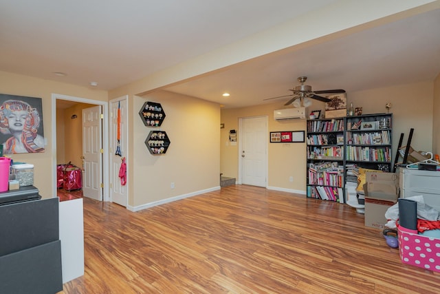 miscellaneous room with ceiling fan, hardwood / wood-style floors, and a wall mounted air conditioner