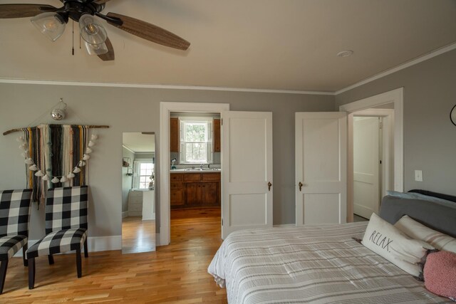 bedroom with ceiling fan, light hardwood / wood-style floors, crown molding, ensuite bath, and sink