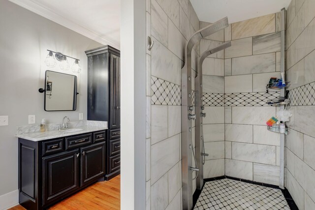 bathroom featuring vanity with extensive cabinet space, crown molding, and wood-type flooring