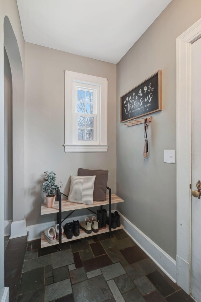 mudroom with dark tile floors