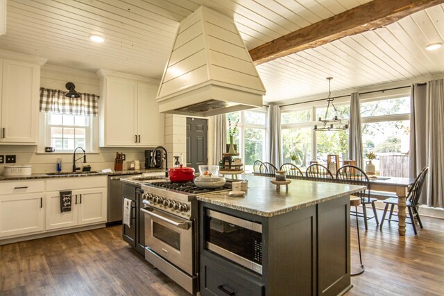 kitchen featuring a center island, dark wood-type flooring, white cabinets, premium range hood, and sink