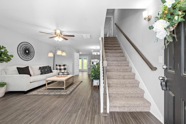 living area featuring visible vents, ceiling fan, and stairway