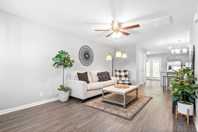 living area with a ceiling fan, visible vents, baseboards, and wood finished floors