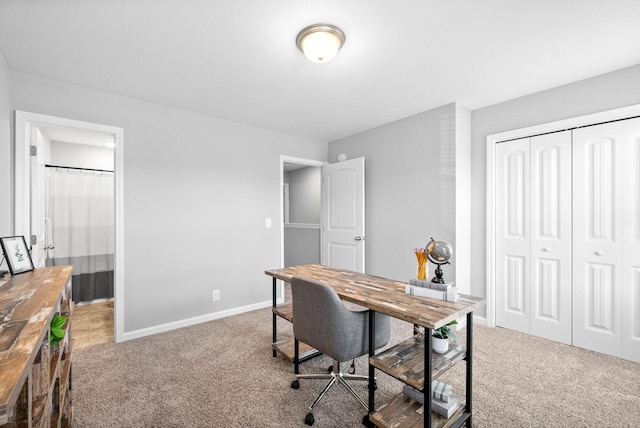 carpeted office space featuring baseboards