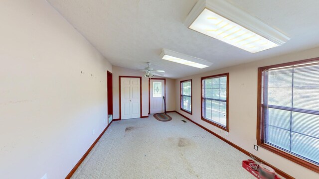 carpeted spare room with ceiling fan and vaulted ceiling