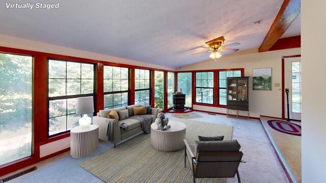 living room featuring a wealth of natural light, carpet floors, and ceiling fan