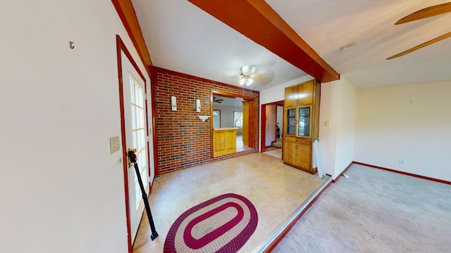 interior space featuring ceiling fan and brick wall