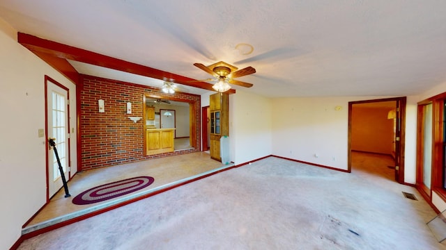 unfurnished living room featuring light carpet, a textured ceiling, and ceiling fan