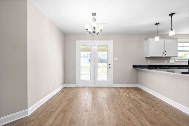 interior space with light hardwood / wood-style flooring, a wealth of natural light, and an inviting chandelier