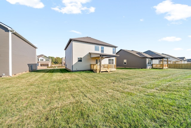 back of property with a deck and a lawn