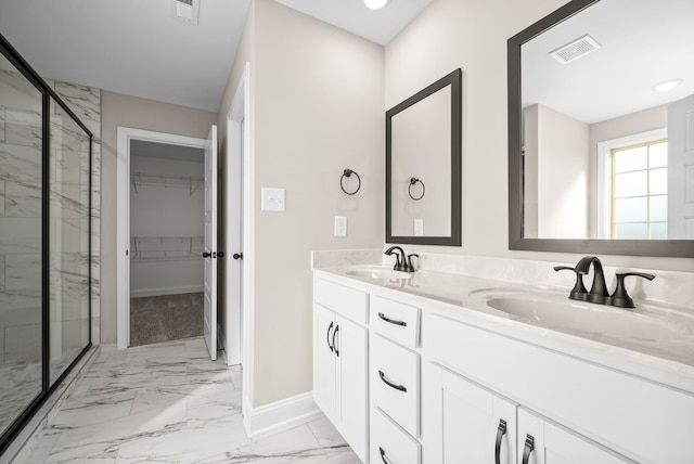 bathroom featuring a shower with door and vanity