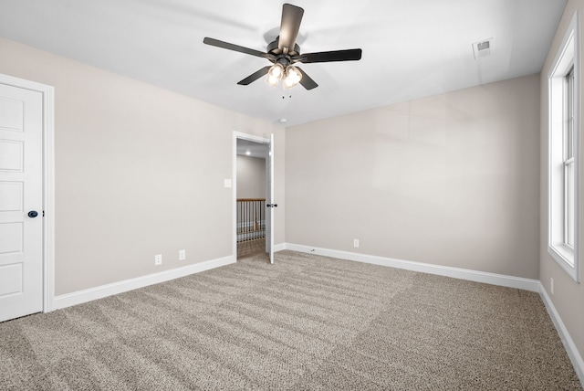 carpeted spare room with ceiling fan