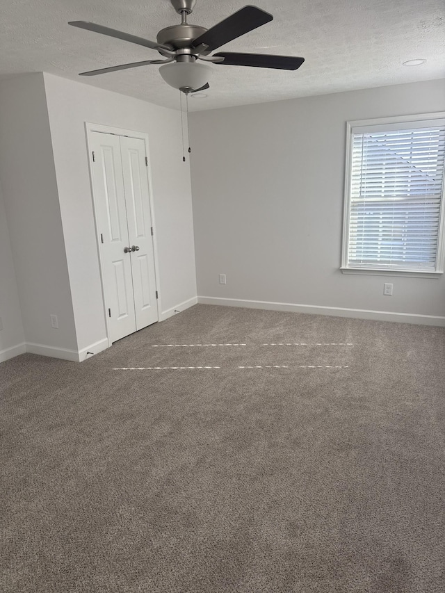 carpeted empty room with a textured ceiling and ceiling fan