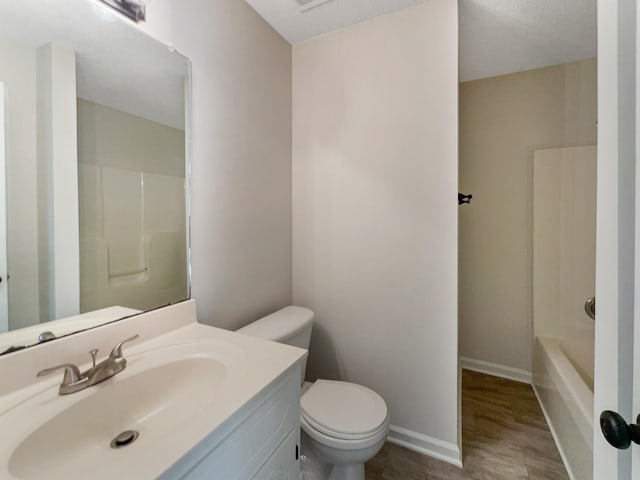 bathroom featuring vanity, wood-type flooring, a textured ceiling, and toilet