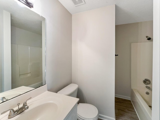 full bathroom featuring shower / bathtub combination, vanity, a textured ceiling, wood-type flooring, and toilet