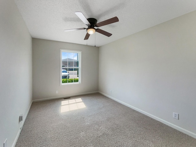 empty room with carpet, ceiling fan, and a textured ceiling