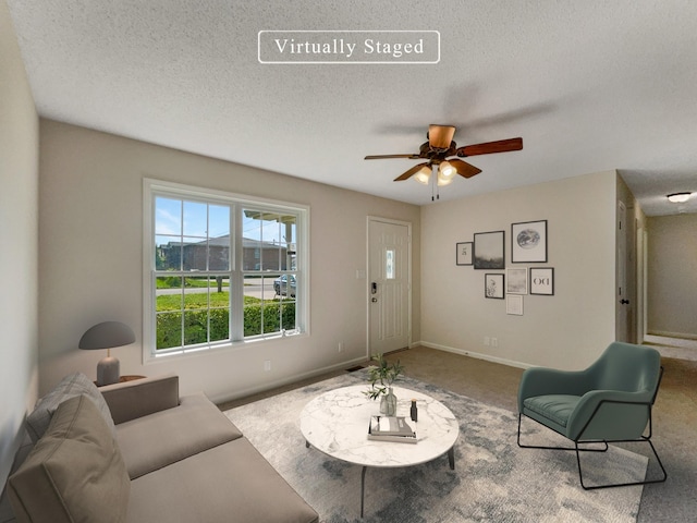 living room with a textured ceiling and ceiling fan