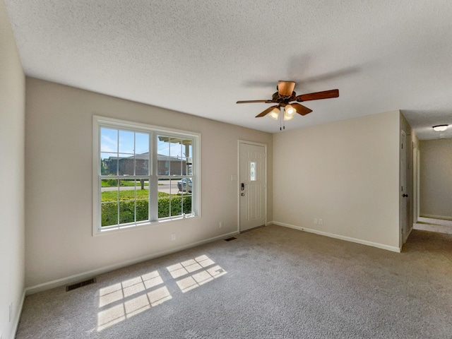 spare room with light carpet, a textured ceiling, and ceiling fan