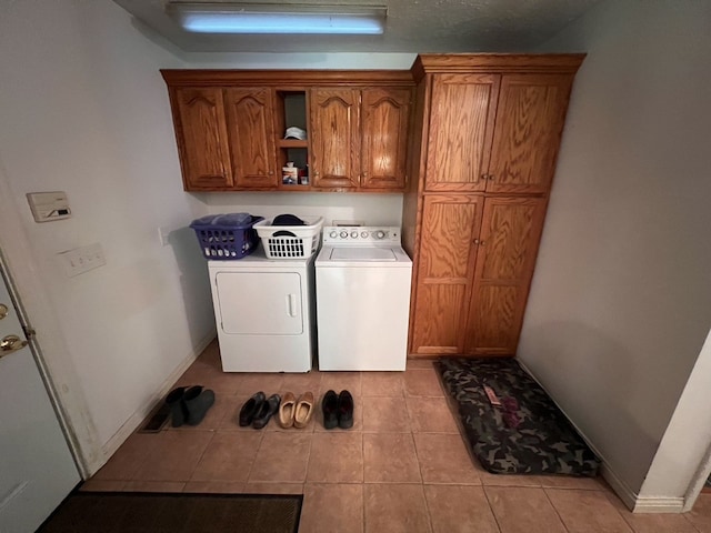 washroom with cabinets, light tile floors, and separate washer and dryer