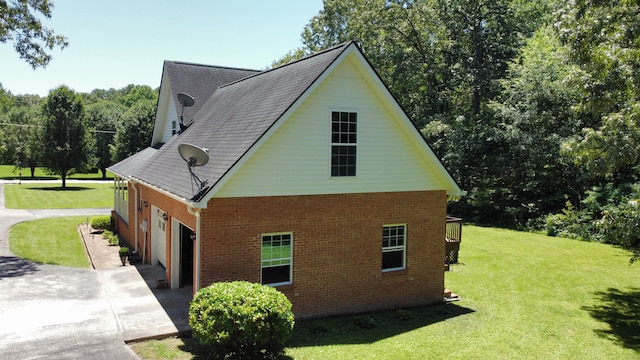 view of side of home with a garage and a lawn