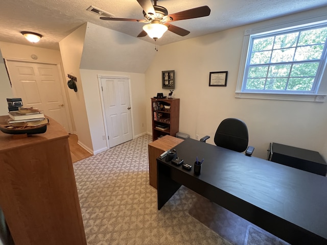 office featuring vaulted ceiling, a textured ceiling, ceiling fan, and carpet floors